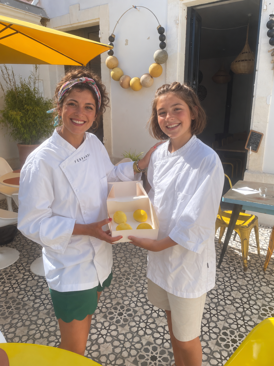 Photo retouchée, visages fictifs : deux participants présentent une boîte de citrons en trompe-l’œil après un cours